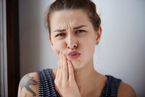 Женщина хмурится от боли Женщина хмурится от дискомфорта